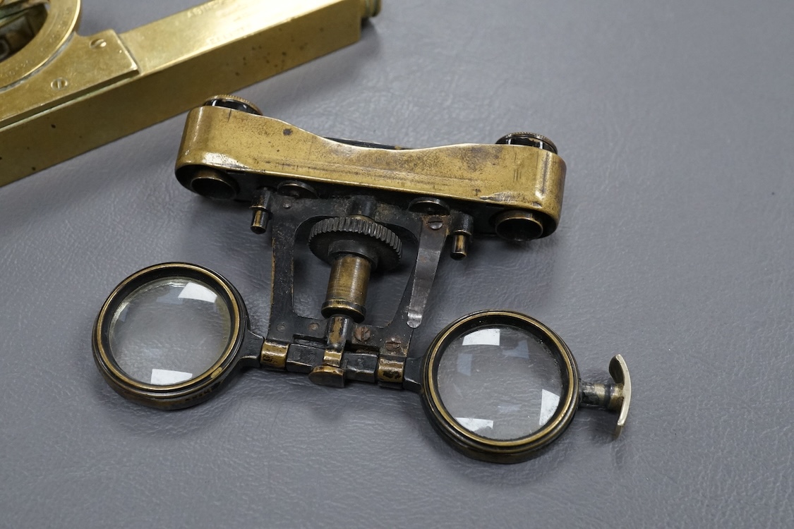 A brass Abney’s level by Elliott, London, 12cm long, together with a pair of folding brass miniature binoculars, 10cm wide.